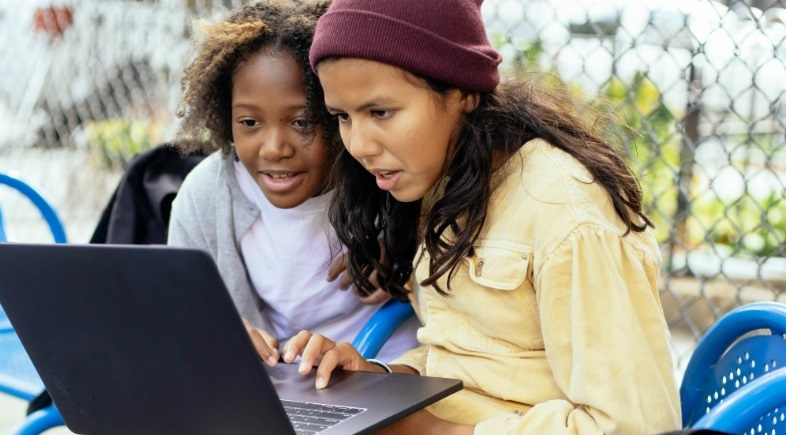 two girls using a laptop computer