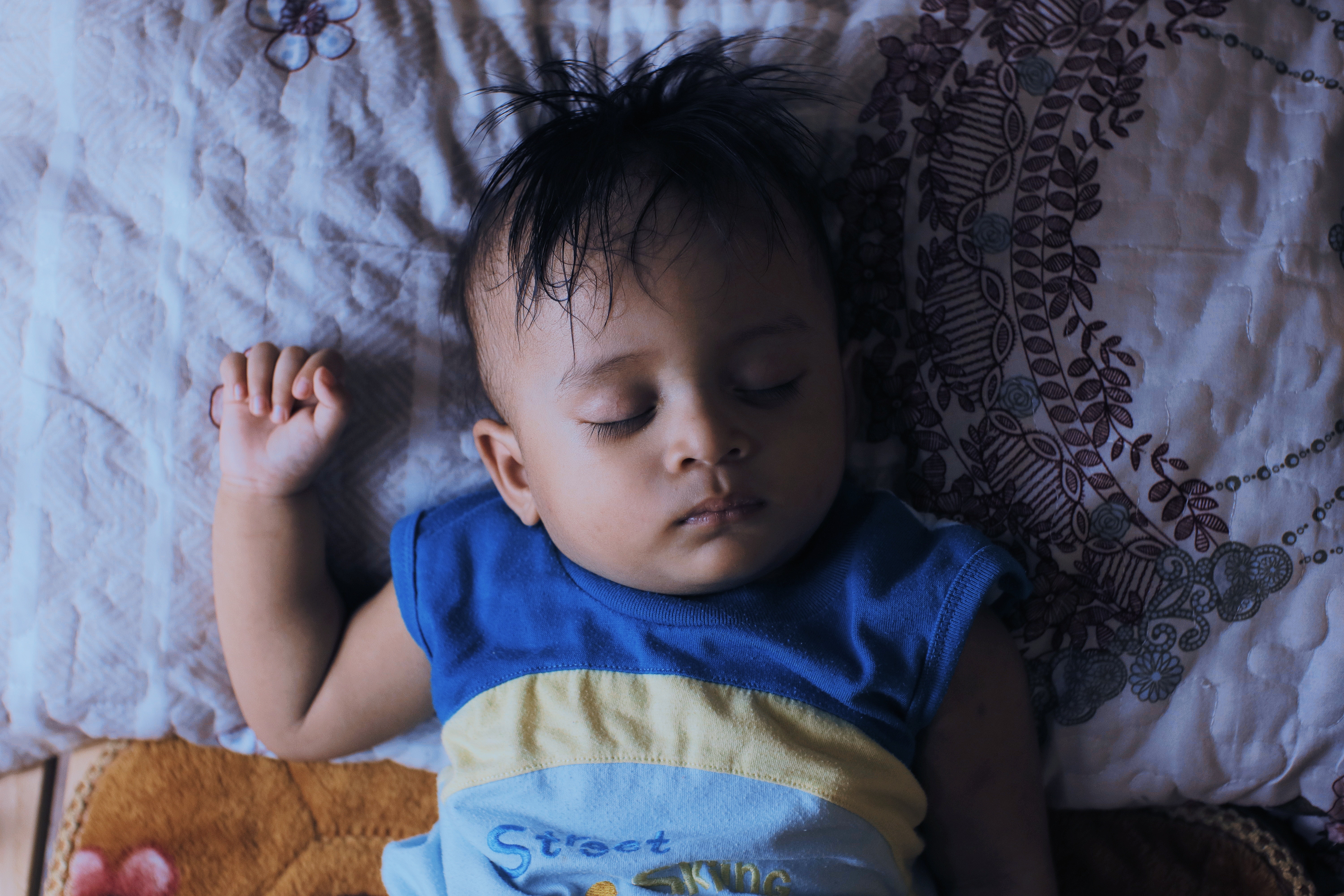 young child sleeping on back